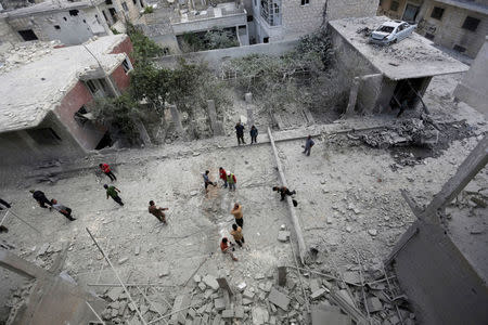 People inspect the damage at a site hit by airstrikes in the rebel-controlled area of Maaret al-Numan town in Idlib province. REUTERS/Khalil Ashawi