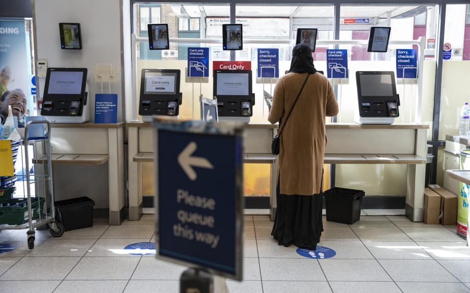 A woman uses a self-checkout at a Tesco - Hollie Adams/Getty Images