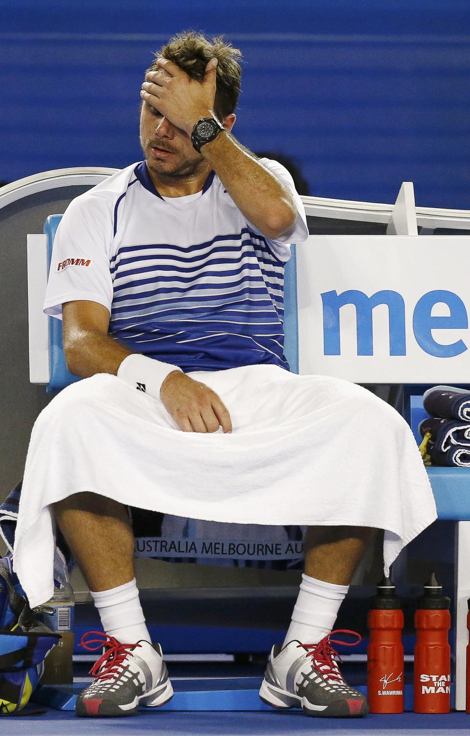 Stan Wawrinka of Switzerland reacts as he sits in his chair during his men's singles semi-final match against Novak Djokovic of Serbia at the Australian Open 2015 tennis tournament in Melbourne January 30, 2015. REUTERS/Thomas Peter (AUSTRALIA - Tags: SPORT TENNIS)