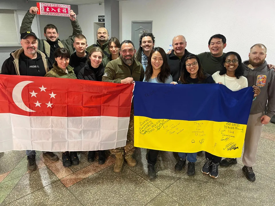 Lam and Baoyan pose for a photo with their Ukrainian partners and other foreign aid workers.