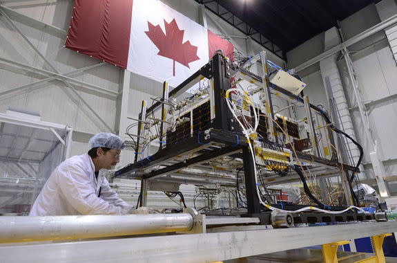 A technician removes the infrared test rig surrounding the asteroid-hunting NEOSSat after the final thermal vacuum test at the David Florida Laboratory located in Ottawa, Ontario. NEOSSat is a dual-mission microsatellite designed to detect pot