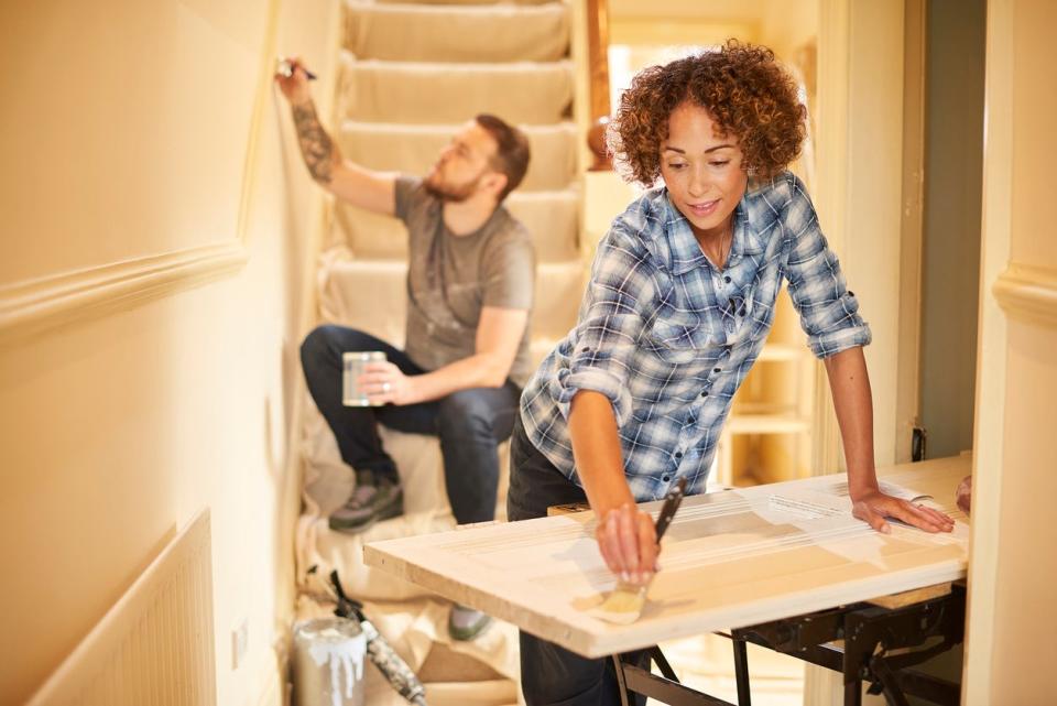 A man and a woman tackle DIY projects in a home. 