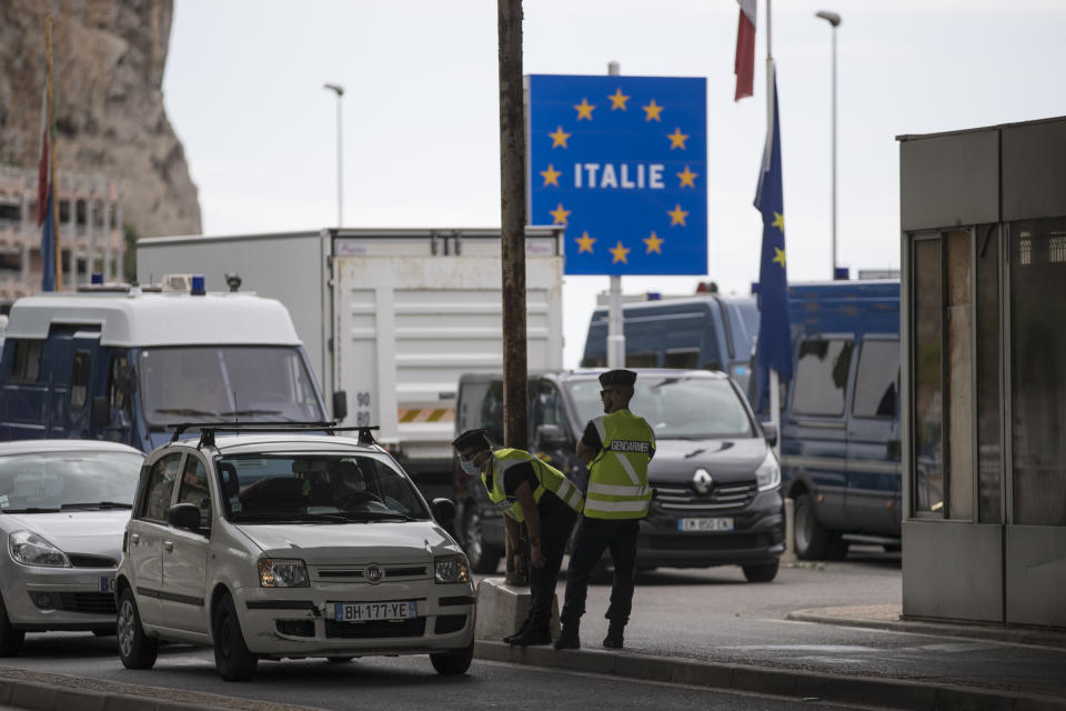 FILE - In this Monday, June 15, 2020 file photo, French gendarmes approach a car at the Saint-Ludovic border check point on the Franco-Italian border in Menton, France. The European Union is set to make public Tuesday June 30, 2020, a list of countries whose citizens will be allowed to enter 31 European countries, but most Americans are likely to be refused entry for at least another two weeks due to soaring coronavirus infections in the U.S. (AP Photo/Daniel Cole, File)