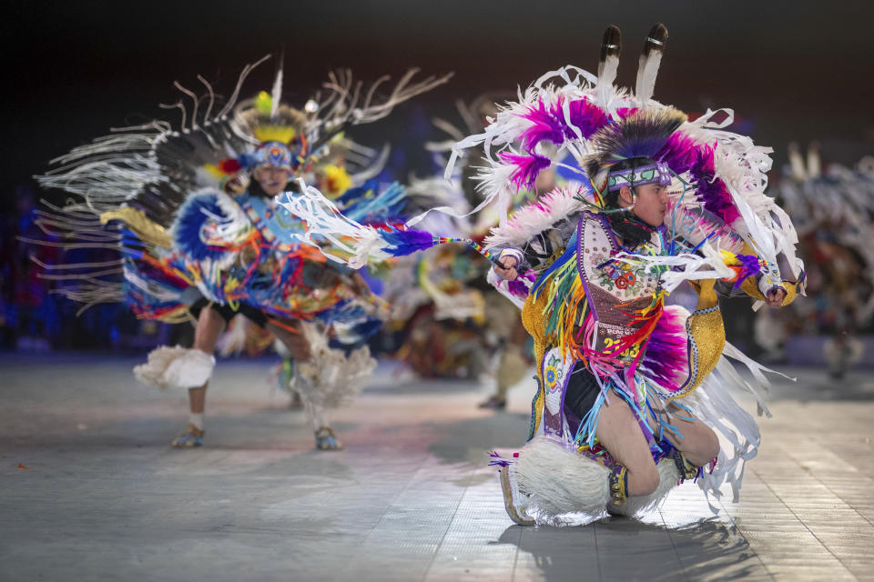 Thirteen year-old Leland Mitsuing, right, of Saskatchewan, Canada competes in the Jr. Boys Traditional competition at the 40th anniversary of the Gathering of Nations Pow Wow in Albuquerque, N.M., Friday, April 28, 2023. Tens of thousands of people gathered in New Mexico on Friday for what organizers bill as the largest powwow in North America. (AP Photo/Roberto E. Rosales)