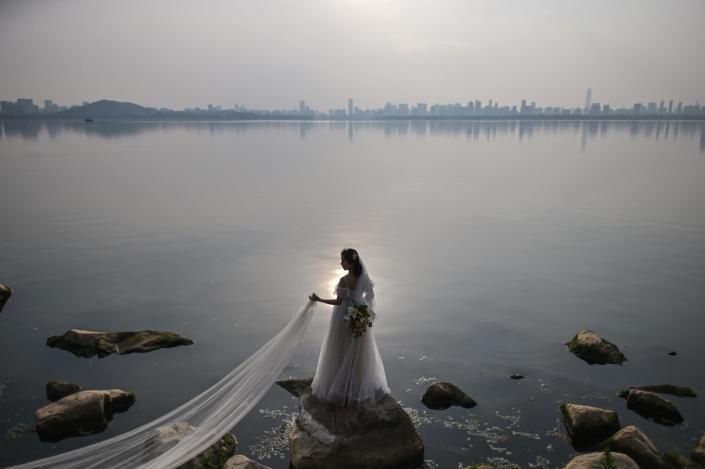 A bride poses for a wedding photograph next to East Lake in Wuhan, China.