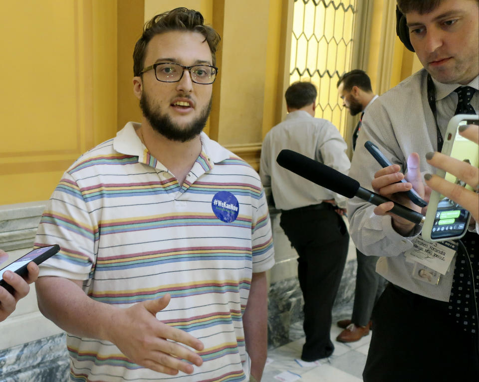 Logan Stenseng, a 20-year-old University of Kansas student, talks with reporters after participating in the dropping of several thousand leaflets in the Statehouse rotunda, Friday, May 3, 2019, in Topeka, Kansas. The protest was in favor of expanding Medicaid, with an expansion bill stuck in a Senate committee. (AP Photo/John Hanna)