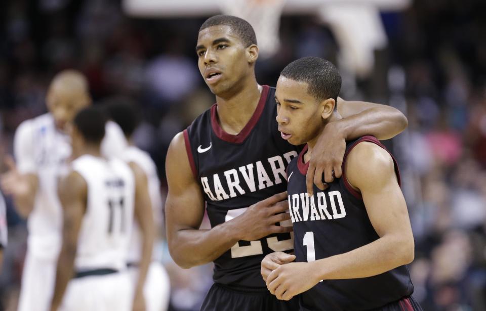 Harvard's Siyani Chambers, right, is comforted by teammate Wesley Saunders late in the second half against Michigan State during the third round of the NCAA men's college basketball tournament in Spokane, Wash., Saturday, March 22, 2014. Michigan State won 80-73. (AP Photo/Elaine Thompson)