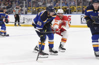 Calgary Flames center Blake Coleman (20) defends against St. Louis Blues center Jordan Kyrou (25) during the second period of an NHL hockey game Thursday, Jan. 27, 2022, in St. Louis. (AP Photo/Joe Puetz)