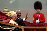 <p>Nelson Mandela, President of South Africa, rides alongside The Queen in a carriage along the Mall on the first day of his state visit to Britain. (PA Archive) </p>