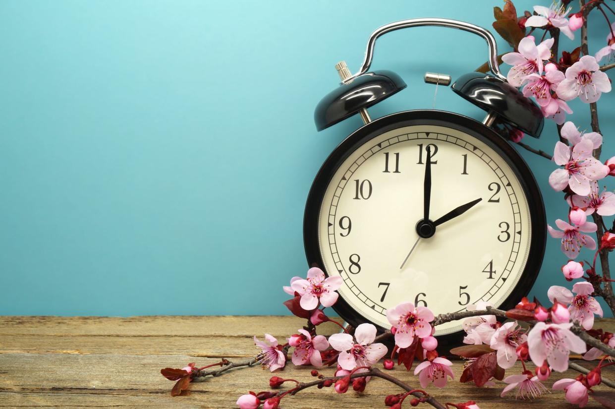 Picture of a clock surrounded by flowers signifies the start of daylight saving time when clocks "spring forward" in March for millions of Americans.
