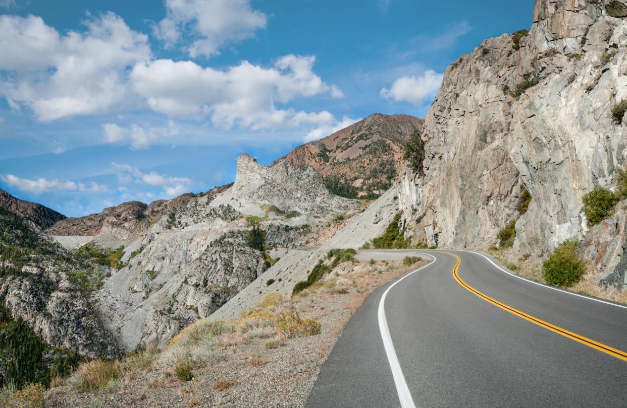 A mountain road curves upward toward Tioga Pass near Yosemite National Park.