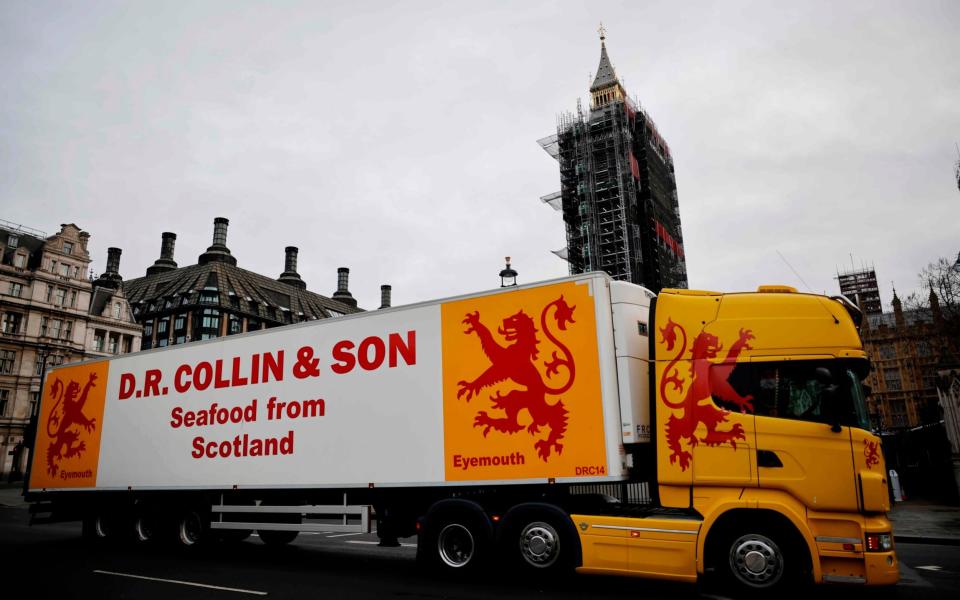 Lorries from Scottish seafood companies drive past the Houses of Parliament in a protest action - AFP