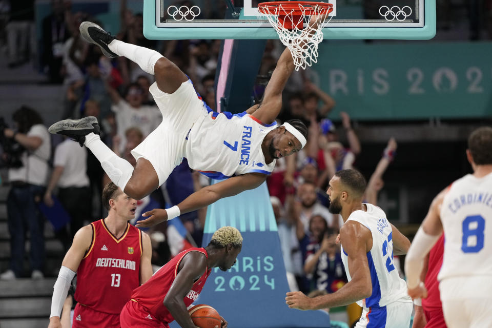 El francés Guerschon Yabusele cuelga del aro tras realizar una clavada ante Alemania, el viernes 2 de agosto de 2024, en los Juegos Olímpicos. El encuentro se disputó en Villeneuve-d'Ascq, Francia. (AP Foto/Mark J. Terrill)