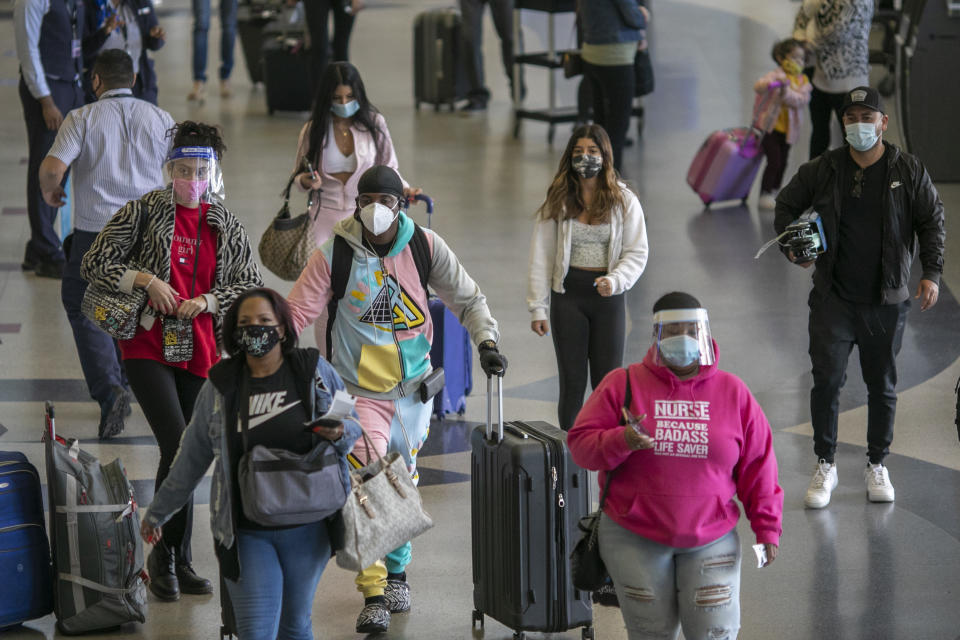 Holiday travelers pass through Los Angeles international Airport on Thanksgiving eve as the COVID-19 spike worsens. Photo by David McNew/Getty Images