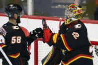 Calgary Flames goalie Dustin Wolf celebrates with Oliver Kylington after the team's win over the Vegas Golden Knights in an NHL hockey game Thursday, March 14, 2024, in Calgary, Alberta. (Larry MacDougal/The Canadian Press via AP)
