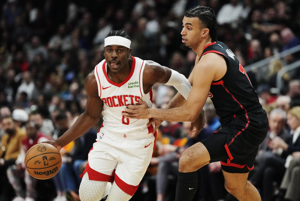 Houston Rockets guard Aaron Holiday (0) drives past Toronto Raptors forward Jordan Nwora (13) during the first half of an NBA basketball game Friday, Feb. 9, 2024, in Toronto. (Frank Gunn/The Canadian Press via AP)