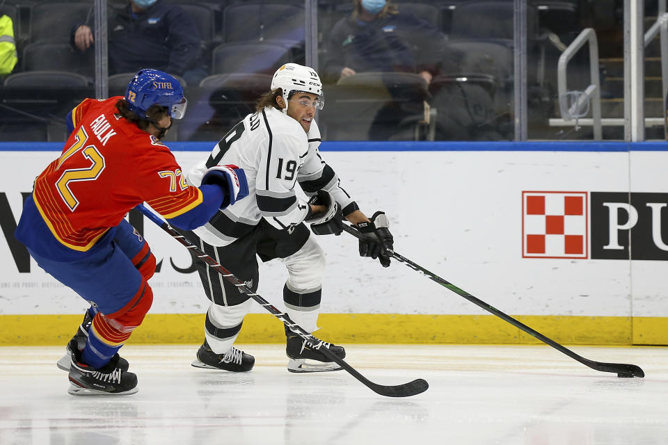 Los Angeles Kings' Alex Iafallo (19) controls the puck in front of St. Louis Blues' Justin Faulk (72) during the first period of an NHL hockey game Monday, Feb. 22, 2021, in St. Louis. (AP Photo/Scott Kane)