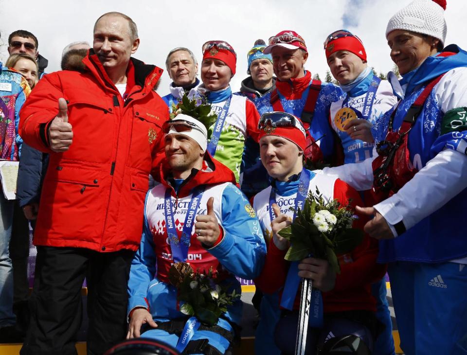 Russian President Vladimir Putin poses with Russian athletes, winners of the cross country 4x2.5km open relay at the 2014 Winter Paralympics, Saturday, March 15, 2014, in Krasnaya Polyana, Russia. (AP Photo/Dmitry Lovetsky)