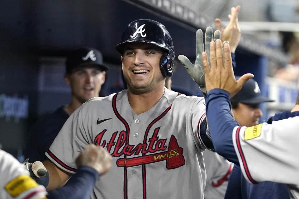 Atlanta Braves' Austin Riley is congratulated in the dugout after hitting a solo home run during the first inning of a baseball game against the Miami Marlins, Saturday, Sept. 16, 2023, in Miami. (AP Photo/Lynne Sladky)