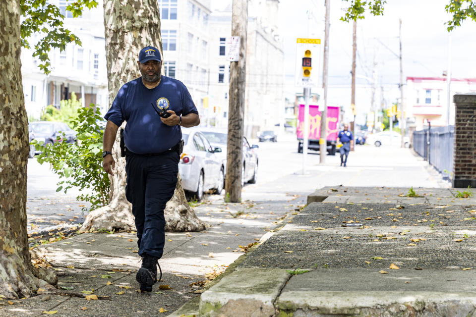 Philadelphia's Crime Scene Unit look for evidence including three bullets scattered along the sidewalk in Philadelphia, on Tuesday, July 4, 2023. Police say a gunman in a bulletproof vest has opened fire on the streets of Philadelphia Monday night, killing several people and wounding two boys before he surrendered to responding officers. (Tyger Williams/The Philadelphia Inquirer via AP)