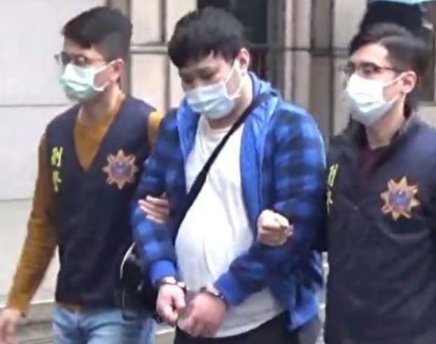 洪姓男子被上銬移送時低頭不發一語，應訊時也否認PO文恐嚇。   圖：刑事局提供