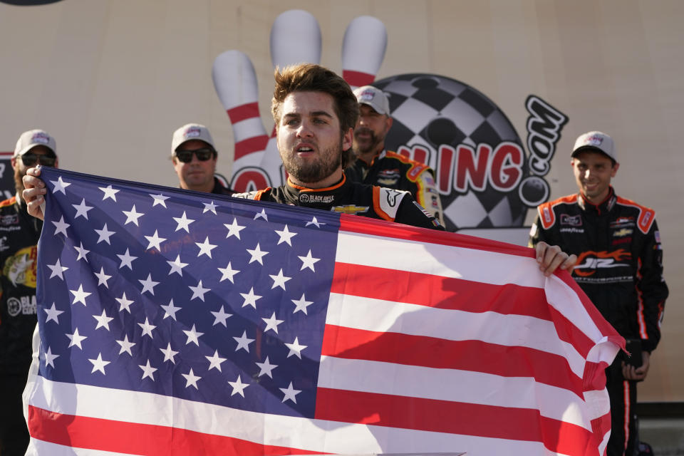 Noah Gragson (9) displays a U.S. flag as he celebrates winning the NASCAR Xfinity auto race in Richmond, Va., Saturday, Sept. 11, 2021. (AP Photo/Steve Helber)