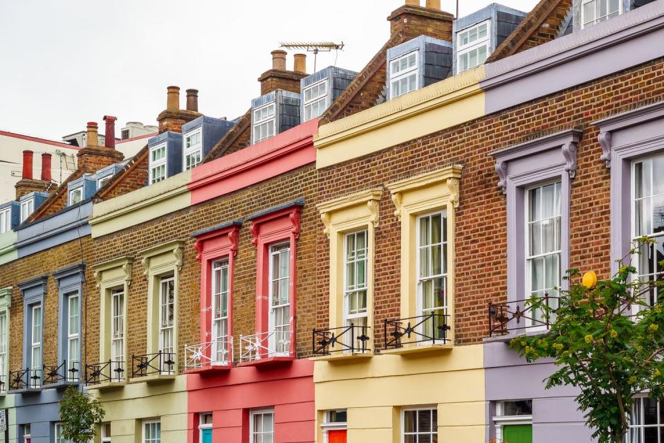 <p>A brick exterior contrasts with pretty pastels on a row of homes in London.</p>