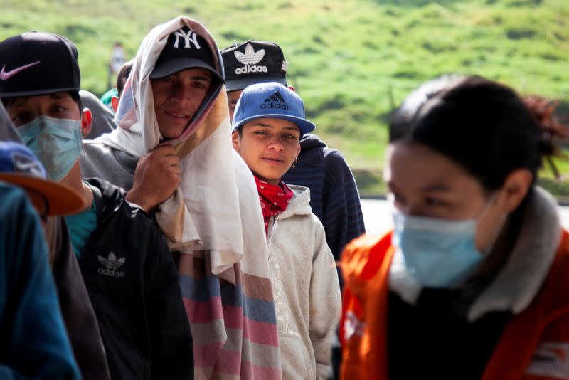 Venezuelan migrants line up to register at a migrant service point run by the International Rescue Committee (IRC) in Chusaca