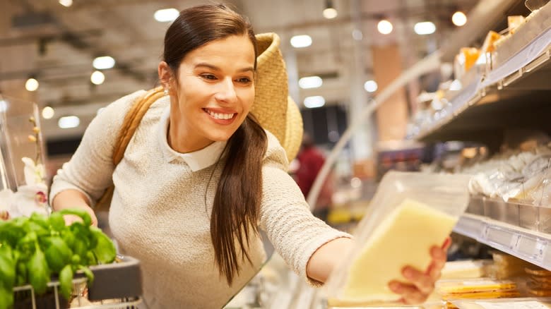 woman at supermarket holding cheese