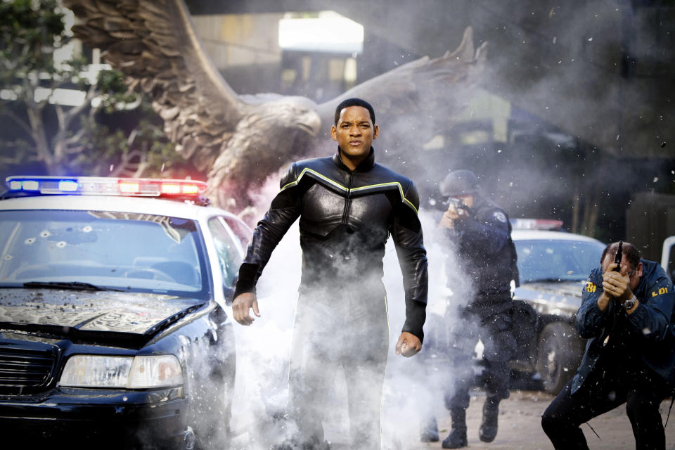 Will Smith walks down a street in a superhero costume