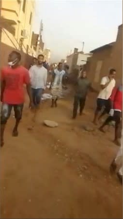 Protesters flee along side streets away from a sit-in, after security forces tried to disperse them, in central Khartoum, Sudan