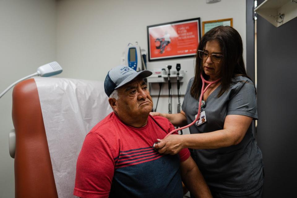 Teresa Vazquez listens to Policarpo Landaverde's chest with a stethoscope