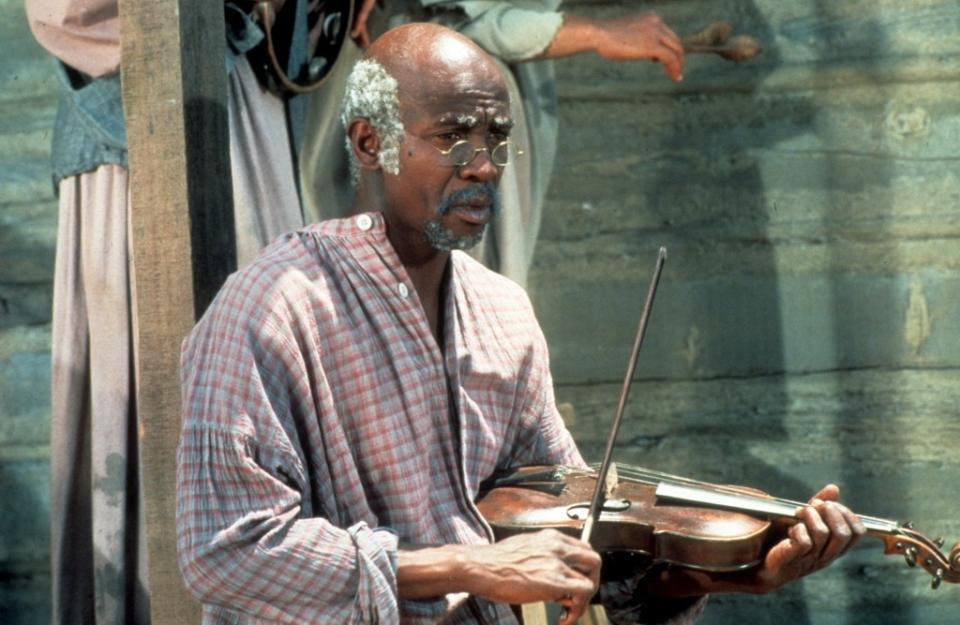 Louis Gossett Jr holding violin in a scene from the television series “Roots” (1977). Getty Images