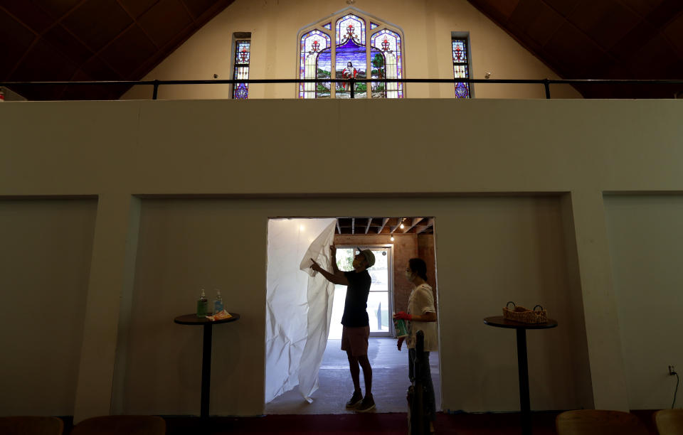 Alamo Heights Baptist Church pastor Bobby Contreras, left, and his wife Hannah, work to clean, sanitize and prepare the church for services this Sunday, in San Antonio, Wednesday, May 6, 2020,. Texas' stay-at-home orders due to the COVID-19 pandemic have expired and Texas Gov. Greg Abbott has eased restrictions on many businesses that have now opened, churches and places or worship may resume live services with 25% capacity. (AP Photo/Eric Gay)