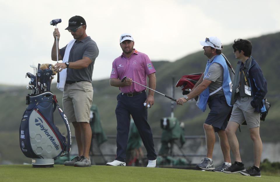 Northern Ireland's Graeme McDowell hands his club over as he leaves the 5th green during a practice round ahead of the start of the British Open golf championships at Royal Portrush in Northern Ireland, Tuesday, July 16, 2019. The British Open starts Thursday. (AP Photo/Jon Super)