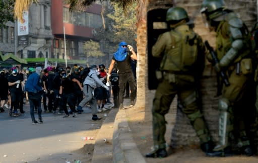 Demonstrators clash with riot police during a protest against the government of Chilean President Sebastian Pinera in Santiago on January 24, 2020