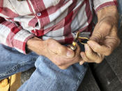 ADVANCE FOR PUBLICATION ON TUESDAY, JUNE 11, AND THEREAFTER - In this April 25, 2019, photo, two-time cancer survivor and medical marijuana cardholder Bill Blazina, 73, smokes a marijuana joint on the deck of his neighbor's home in Waldport, Ore. Blazina also uses a high-potency marijuana oil as a medical marijuana patient but he can't afford it at a recreational marijuana store. Blazina has learned how to make his own oil in a rice cooker after watching online videos. (AP Photo/Gillian Flaccus)