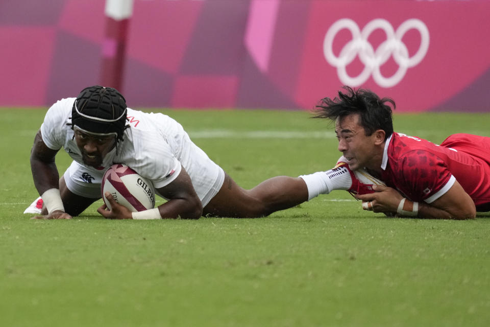 Canada's Nathan Hirayama tackles Kevon Williams of the United States in their men's rugby sevens 5-8 placing match at the 2020 Summer Olympics, Wednesday, July 28, 2021 in Tokyo, Japan. (AP Photo/Shuji Kajiyama)