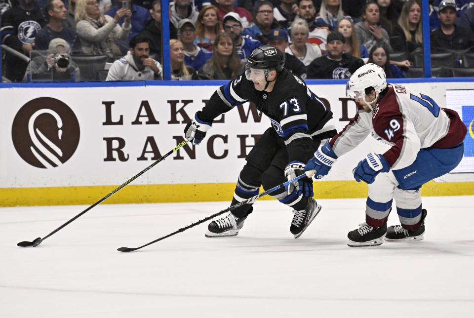 Tampa Bay Lightning left wing Conor Sheary (73) and Colorado Avalanche defenseman Samuel Girard (49) compete for the puck during the second period of an NHL hockey game Thursday, Feb. 15, 2024, in Tampa, Fla. (AP Photo/Jason Behnken)