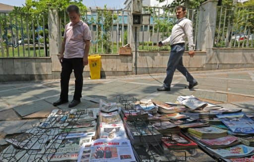 A man reads newspaper headlines in the Iranian capital Tehran