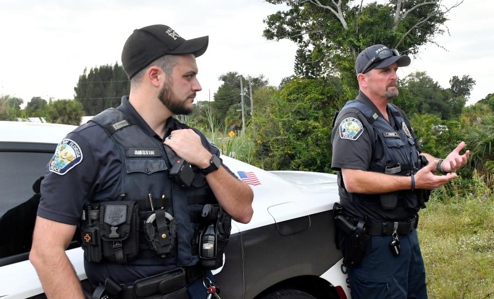 Palm Bay Community Resource Officers Ryan Austin and Dave Porter talk after checking in on a homeless couple, taking them supplies including new socks, insect repellent and water donated by area churches and individuals.