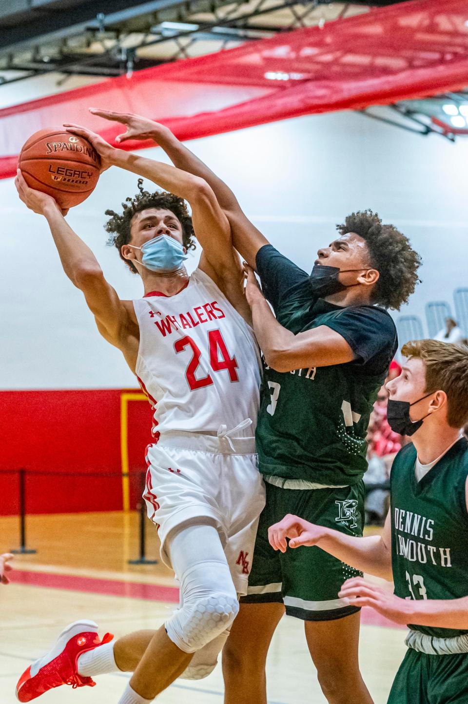 New Bedford's Dezmond Brunskill arches back to get the shot over Dennis-Yarmouth's Darius Azor.