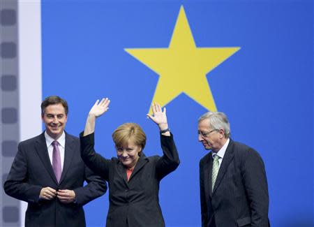 German Chancellor Angela Merkel, leader of the Christian Democratic Union (CDU), gestures amid CDU's top candidate for European parliamentary elections David McAllister (L) and Jean-Claude Juncker, former prime minister of Luxembourg and top candidate of European People's Party for European parliamentary elections, during the CDU congress in Berlin April 5, 2014. REUTERS/Stefanie Loos