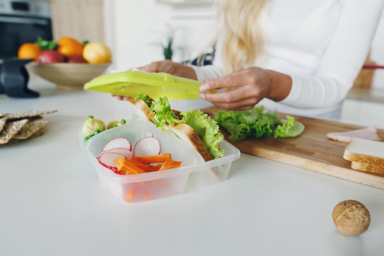 mother preparing school lunch for children's in home kitchen