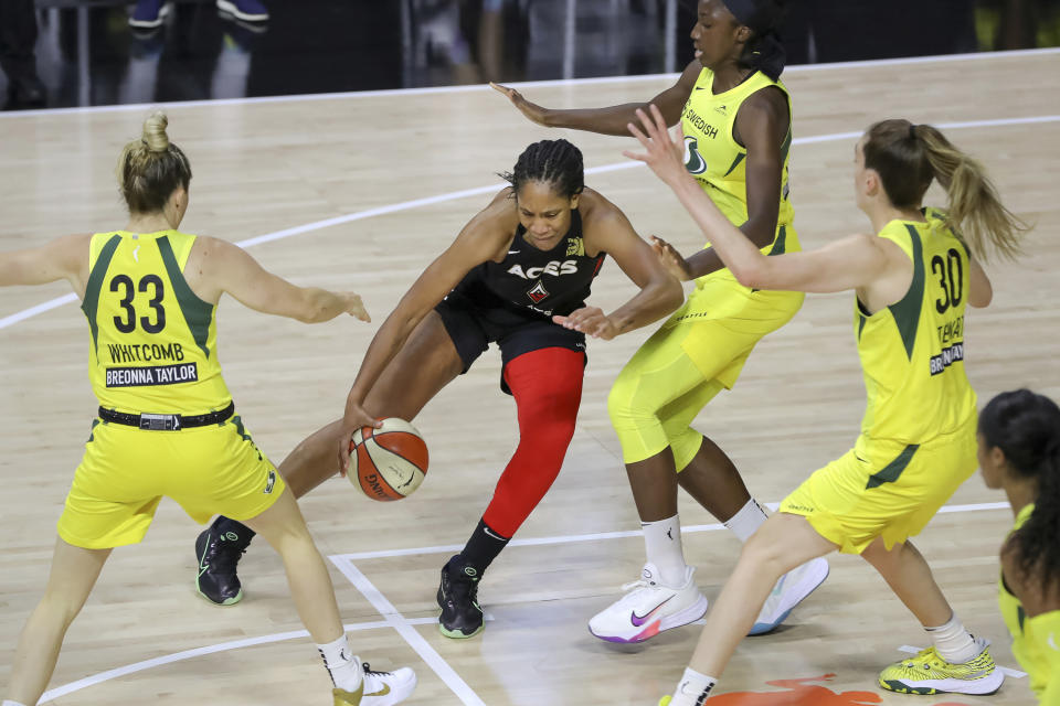 A'ja Wilson dribbles in front of three Storm players. 