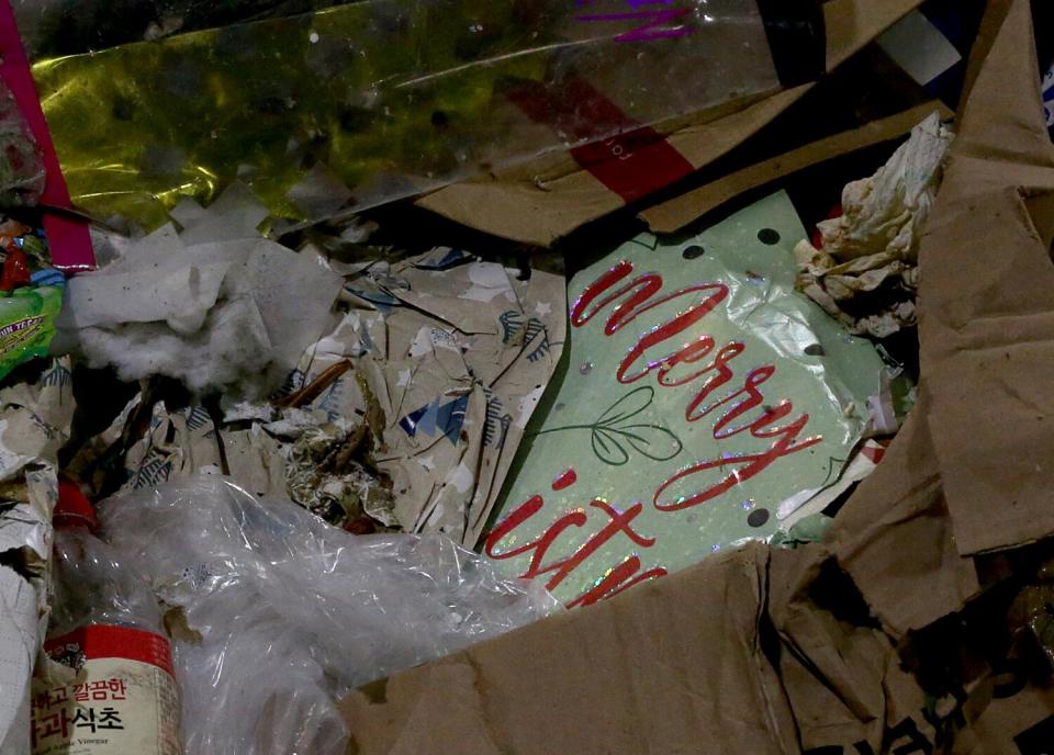 A pile of holiday wrapping paper and cardboard and plastic container waste.