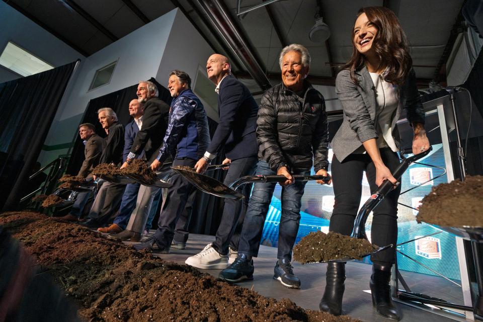 Dignitaries, including Michael, Mario and Marissa Andretti pick up dirt for photos during the groundbreaking event for the new Andretti Global motorsports headquarters facility Tuesday, Dec. 6, 2022 in Fishers.