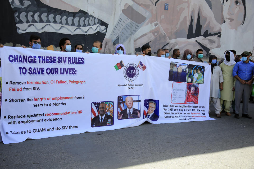 In this June 25, 2021 photo, former Afghan interpreters hold placards during a demonstrations against the US government, in front of the US Embassy in Kabul, Afghanistan. The Biden administration says it will evacuate about 2,500 Afghans who worked for the U.S. government and their families to a military base in Virginia pending approval of their visas. The administration notified Congress on Monday that the Afghans will be housed at the Fort Lee Army base south of Richmond starting next week. (AP Photo/Mariam Zuhaib)