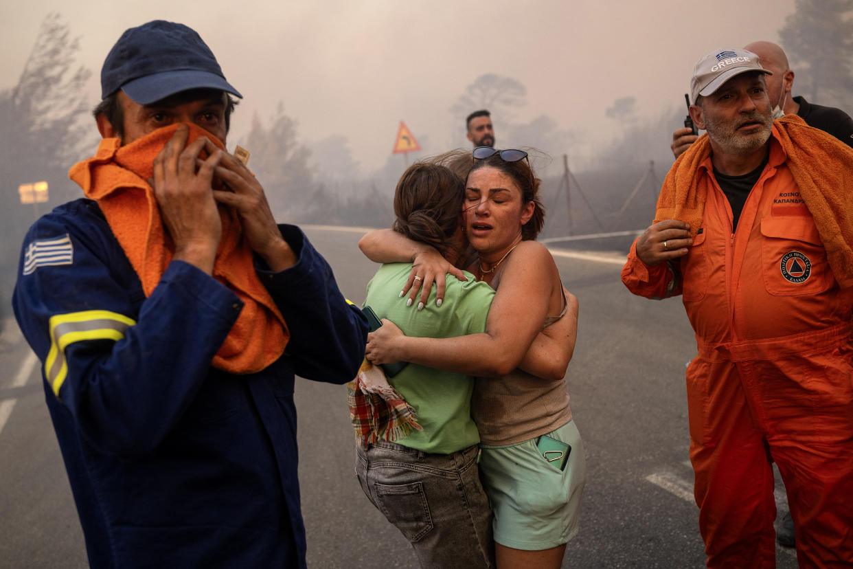 Women embrace after being rescued during a wildfire in Varnavas, north of Athens, on Sunday. 