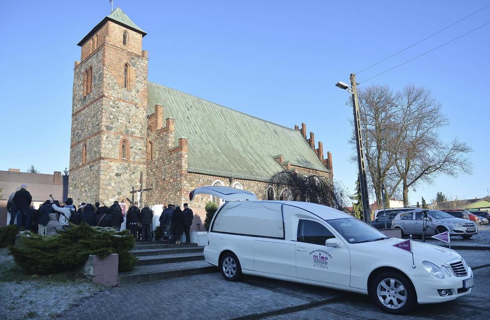 People gather in front of the church for a funeral mass of the Polish truck driver Lukasz Urban, who was killed in the Berlin Christmas market attack, in the church in Banie, Poland, Friday, Dec. 30, 2016, during the funeral ceremonies. (AP Photo/Lukasz Szelemej)